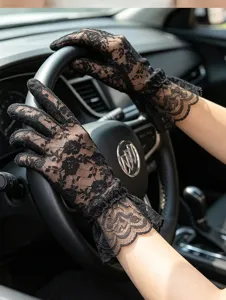 Detailed shot of black lace driving gloves showcasing delicate floral patterns and ruffled cuffs.