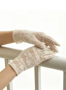 Close-up detail of elegant floral lace white gloves, delicate mesh design for summer tea party.
