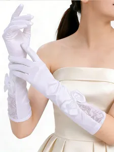 detail shot of elegant long white satin wedding gloves with lace and bow for bridal dress