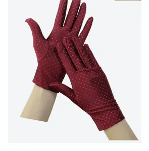 Detailed view of women elegant red polka dot elastic gloves, soft breathable summer sun protection.