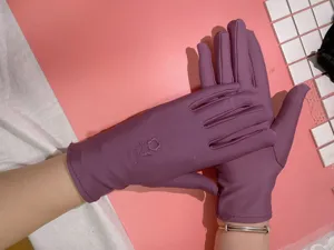 Vista dettagliata di guanti da sole in spandex viola sottile da donna con delicato ricamo.