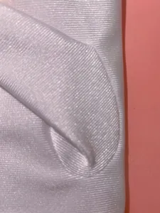 Primo piano di guanto in spandex bianco che mostra la texture a coste altamente elastica.