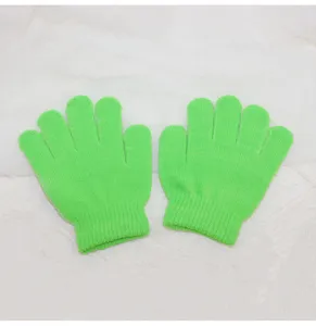 Close-up detail of bright green kids knit gloves, showing the fine texture and craftsmanship.