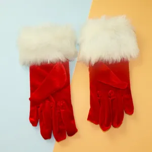 Vue rapprochée de gants courts en velours rouge avec poignets en fausse fourrure blanche doux.