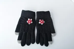 Detail view of women winter warm knitted touch screen gloves with cute floral decoration.