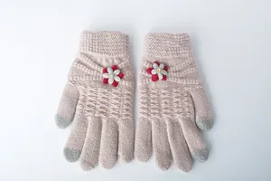 Close-up view of the knitted touchscreen winter gloves featuring delicate floral applique.