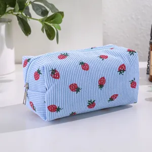 Detailed view of the cute blue corduroy strawberry print cosmetic bag and storage pouch.