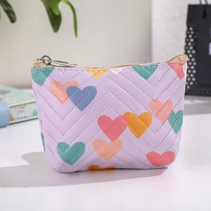 Close-up detail of the cute purple leather coin purse featuring colorful heart patterns and zipper.