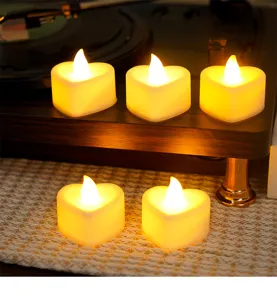 Close-up detail of warm heart-shaped LED electronic candles, creating a romantic atmosphere.