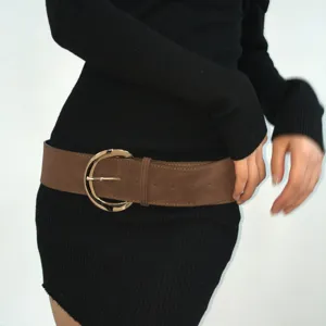 Detail shot of wide brown suede women waist belt with golden round buckle for dress coats.