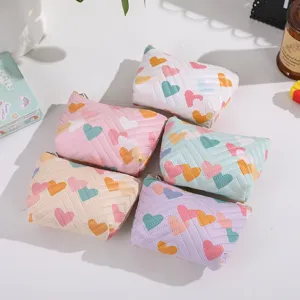 Cute leather cosmetic pouch with colorful heart print, portable quilted makeup storage bag.