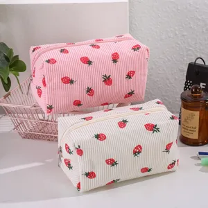 Detail view of cute corduroy strawberry makeup bag, portable travel cosmetic storage pouch.
