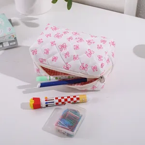 Pink quilted cosmetic bag with cute bow prints, large capacity portable storage pouch detail.