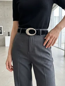 Detailaufnahme eines schwarzen Damen-Wildledergürtels mit auffälliger ovaler Silberschnalle.