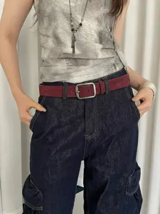 Vintage suede women belt with square buckle paired with denim jeans, detail view showing texture