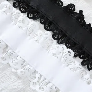 Gros plan de la ceinture élastique large en dentelle noire et blanche avec motif ajouré