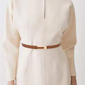 Schmaler brauner Ledergürtel im Detail mit eleganter Metallschnalle für feminine Kleidung.