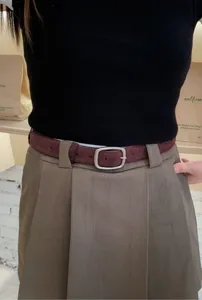 Λεπτομέρεια ζώνης από vintage σουέτ δέρμα με ρετρό ασημί αγκράφα φορεμένη σε ρούχα.