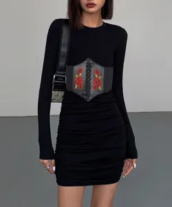 Primo piano sui dettagli della elegante cintura in pelle nera con ricamo floreale.