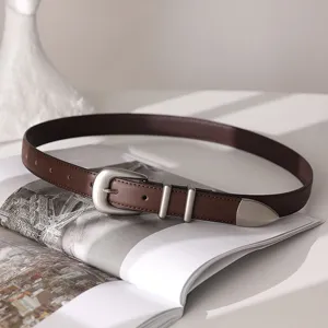 Detailed view of women's vintage brown leather belt with silver metal buckle, chic and versatile.
