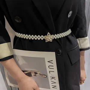 Elegant women's pearl waist belt detail, featuring layered pearls and sparkling star rhinestone buckle.