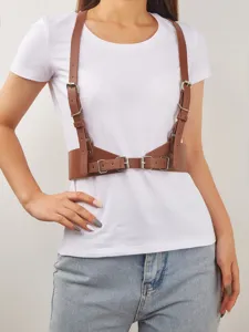 Vista di dettaglio di elegante cintura harness in pelle marrone con fibbie metalliche.