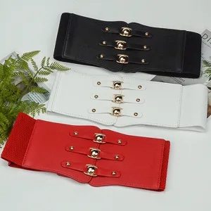 Detailed shot of wide elastic corset belts in black, white, and red with metal snap buckles.