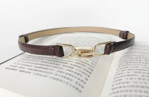 Detail view of a slim dark brown women belt with chic gold interlocking buckle for dresses.