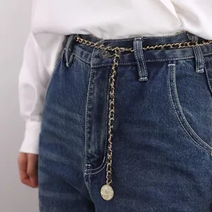 Close-up detail of the elegant metal chain waist belt featuring leather weave and coin pendant.