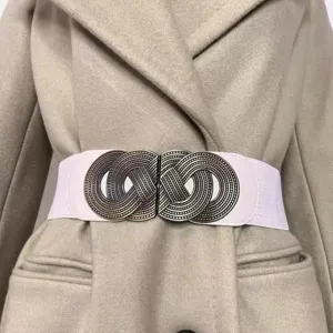 Close-up of a women's elastic wide waist belt with vintage metal buckle on beige coat.