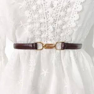 Women's thin leather belt detail, dark brown strap with stylish golden buckle, versatile accessory.