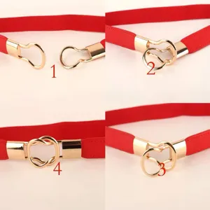 Red elastic waist belt with gold heart-shaped buckle, perfect detail view for dresses.