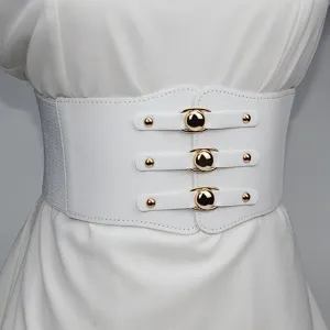 Close-up detail of the wide white elastic corset belt with stylish gold metal buckle accents.