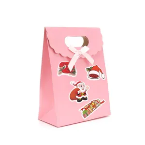 Bolsa de regalo de navidad rosa con lazo blanco y bonitos adhesivos festivos de fiesta