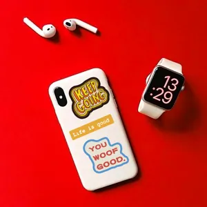 Close up detail of inspirational graffiti stickers on white phone case with red background