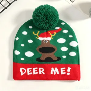 Nahaufnahme Detail der weihnachtlichen Strickmütze mit niedlichem Rentier und flauschigem Pompon.