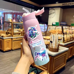 Tragbare Wasserflasche mit Farbverlauf und bunten Einhorn-Grafity-Aufklebern verziert.
