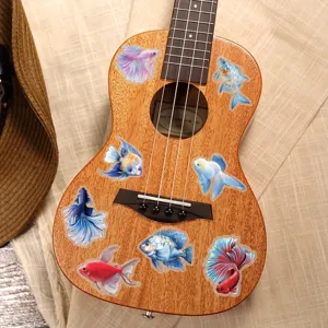 Close-up detail of waterproof fish stickers displayed on ukulele surface, vibrant decoration.