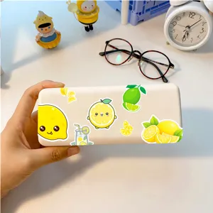 Close-up of a cute lemon sticker decorated storage case on a clean white desk setup.