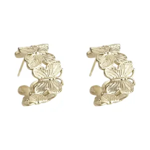 Gold butterfly hoop earrings, detailed view of minimalist metal fashion jewelry for women.