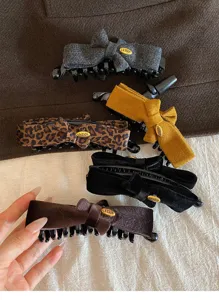 Detailed view of vintage bow hair claw clip, elegant fabric banana clip for women hair styling.