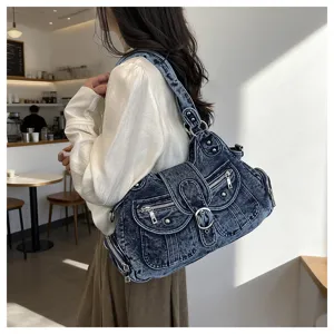 Detailed view of the vintage washed denim shoulder bag with multi-pockets and metal buckles.
