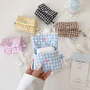 Gros-plan d'un étui de rangement pour écouteurs à carreaux avec bouton-pression et crochet.