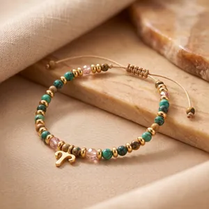 Gros plan détaillé d'un élégant bracelet en perles de pierre naturelle avec pendentif Bélier.