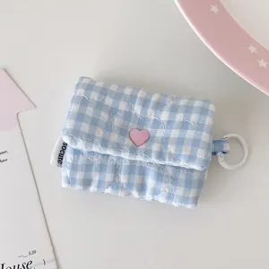 Vue détaillée de la pochette d'écouteurs à carreaux bleu et blanc, joli bouton cœur et anneau.