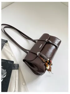 Dark brown leather shoulder bag stylish commuter armpit bag with chic beaded tassel charms.