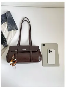 Brown PU leather shoulder bag for women, chic underarm handbag with stylish tassel charm.