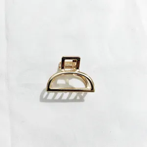 Detailed view of minimalist gold metal hair claw clip, elegant geometric hair accessory.