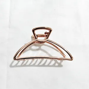 Detailed view of a stylish rose gold metal hair claw clip, perfect for elegant updos and buns.