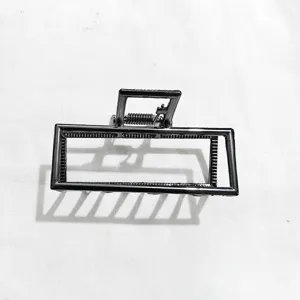 Detailed view of the sleek geometric metal hair claw clip in dark alloy finish.